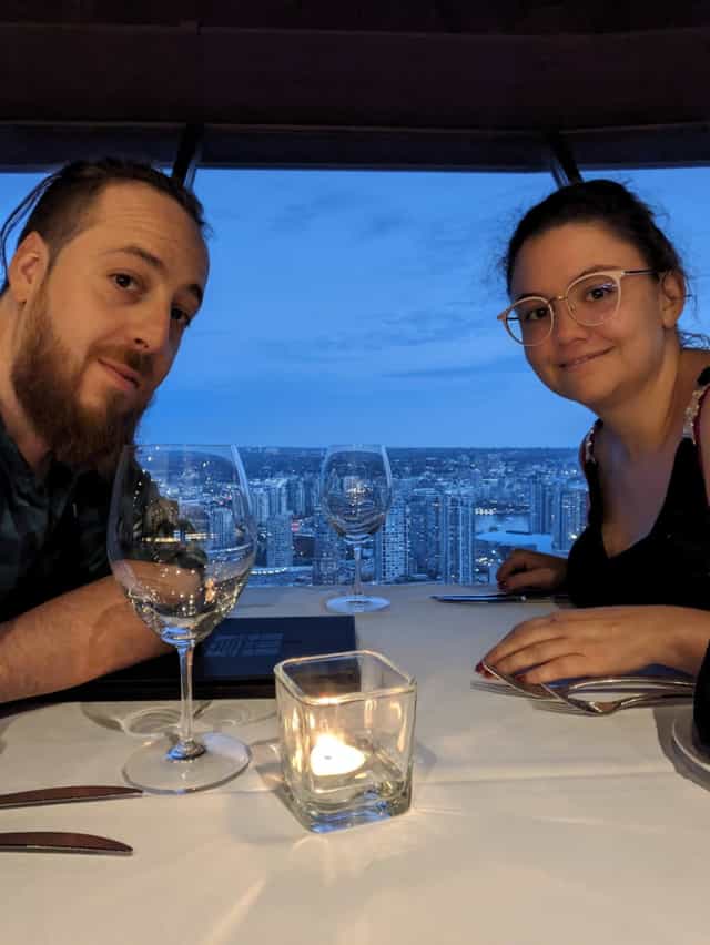 Cécile et Quentin au restaurant, la ville en arrière-plan